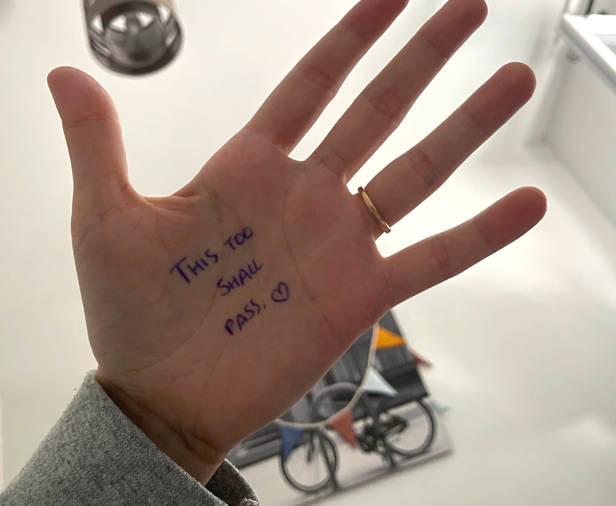 A picture of my hand with a message written on my skin: "This too shall pass".