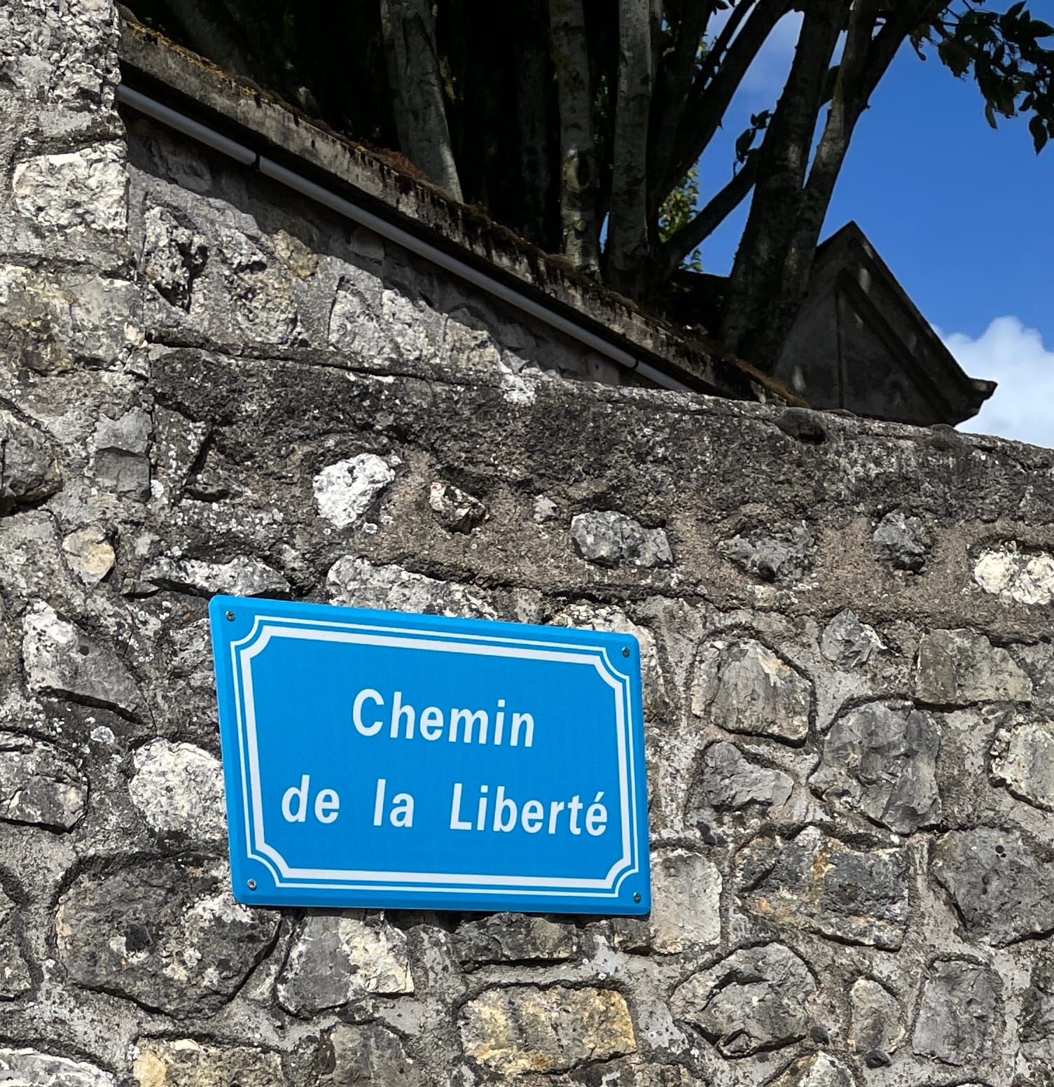 Une photo d'une plaque de rue qui se nomme "Chemin de la Liberté".