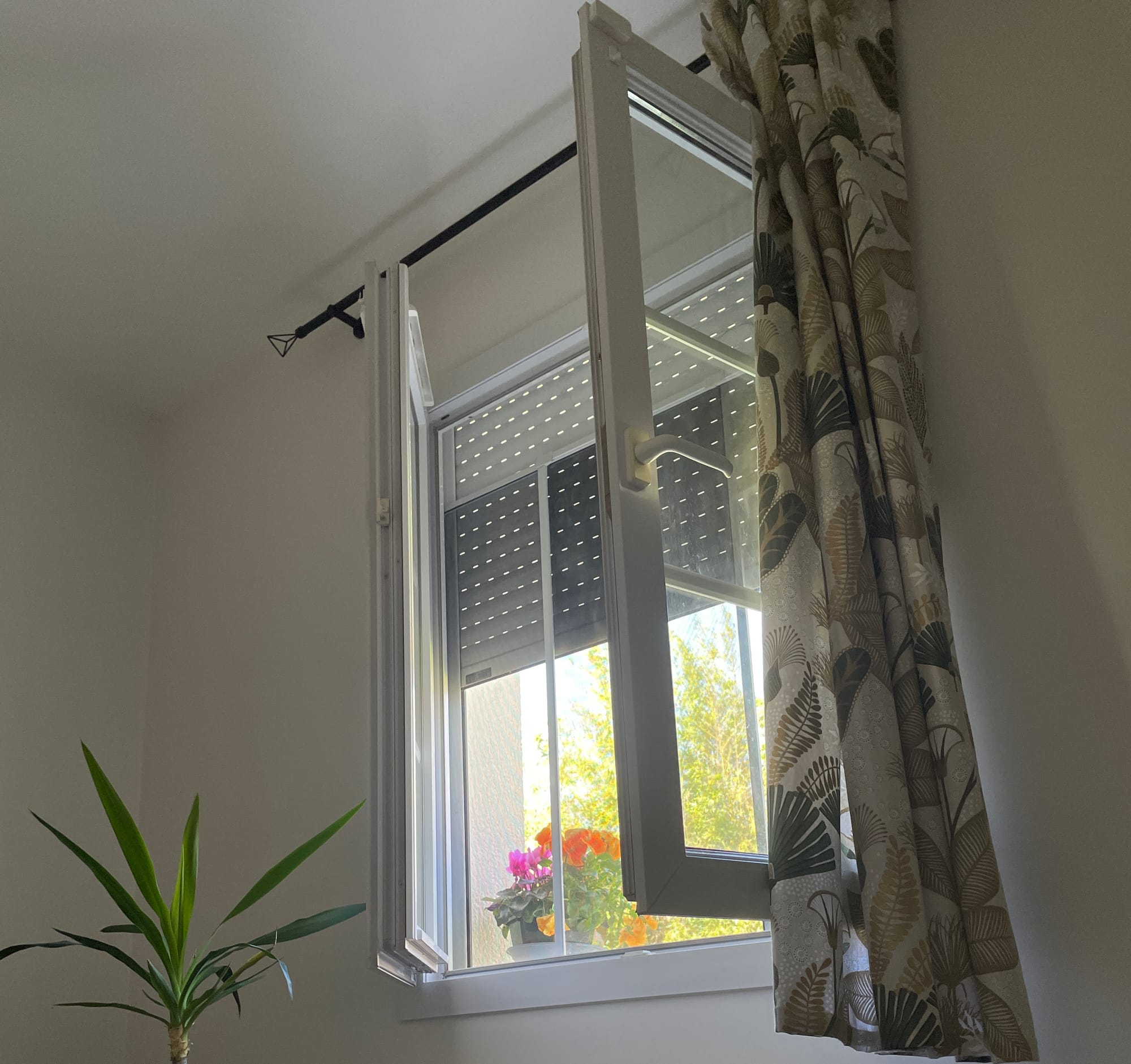 Ma fenêtre, avec le volet à demi ouvert. Une douce lumière filtrant de l'extérieur, et des fleurs sur le rebord.