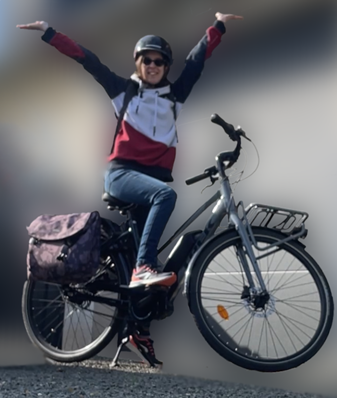 A picture of my on my electric bike in a victory pose with a big smile.