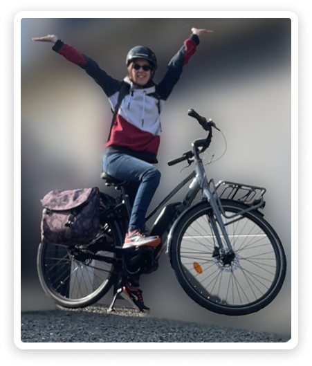 Une photo de moi sur mon vélo électrique, les bras levés en signe de victoire.
