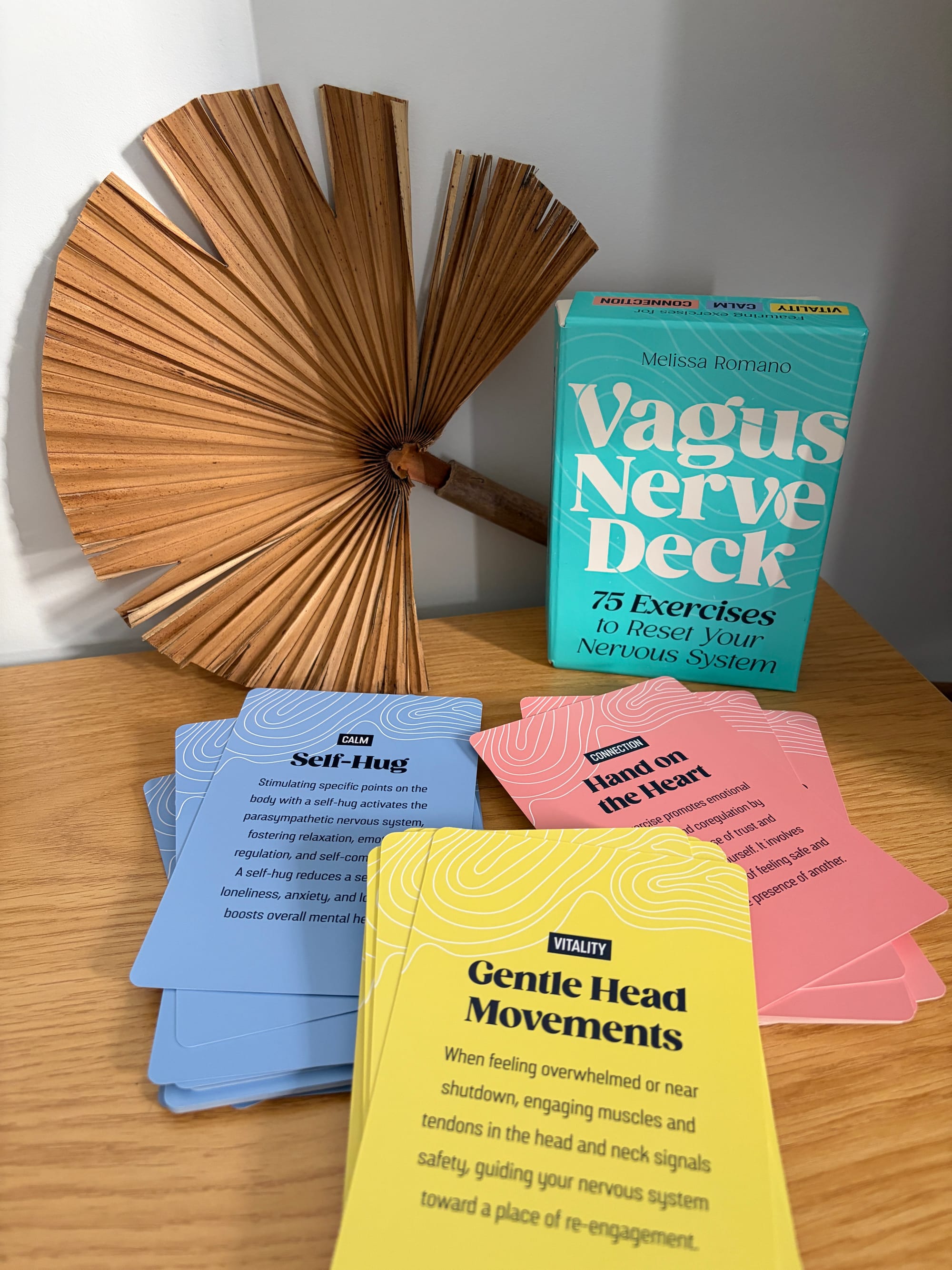 Some cards from the vagus nerve deck: a blue one (Calm - self hug), a red one (Connection - Hand on heart), and a yellow one (Vitality - Gentle head movements)